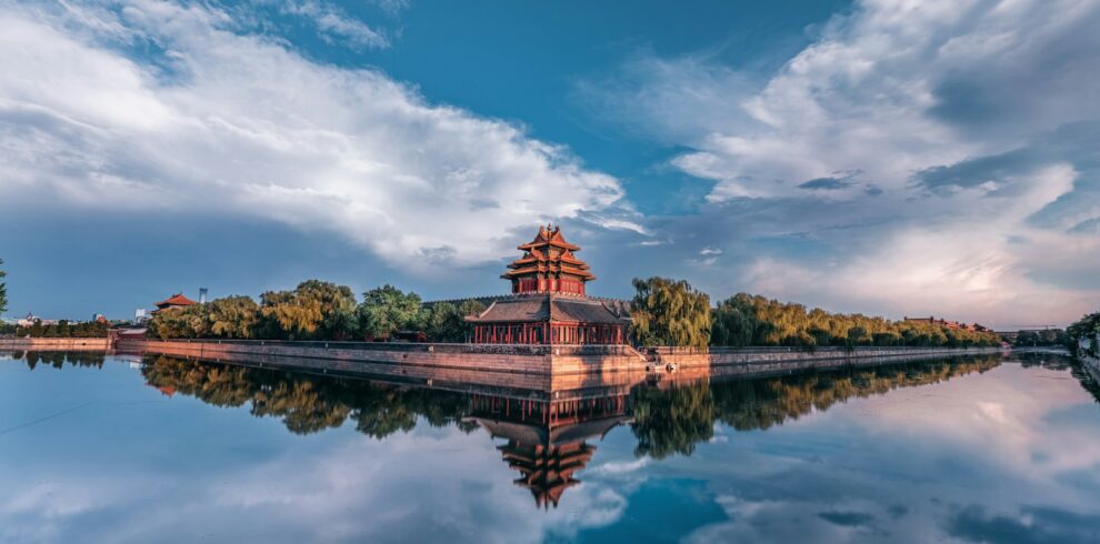 brown and green building near body of water under blue sky during daytime