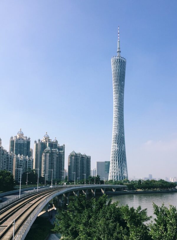 a very tall tower towering over a city next to a river